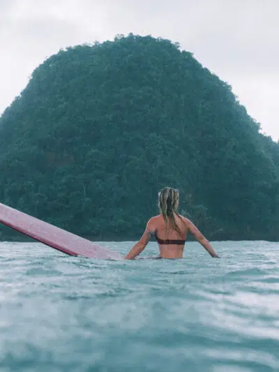 Surfers in the water in front of Red Island, Java