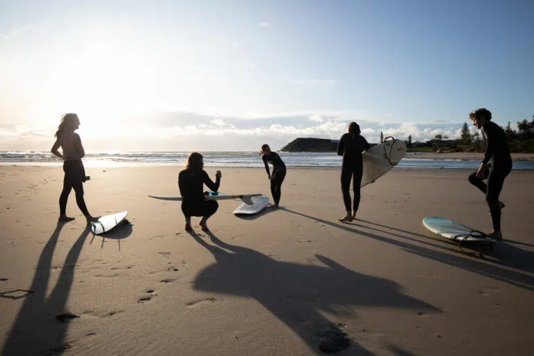 Surfers carrying boards on the beach at Spot X