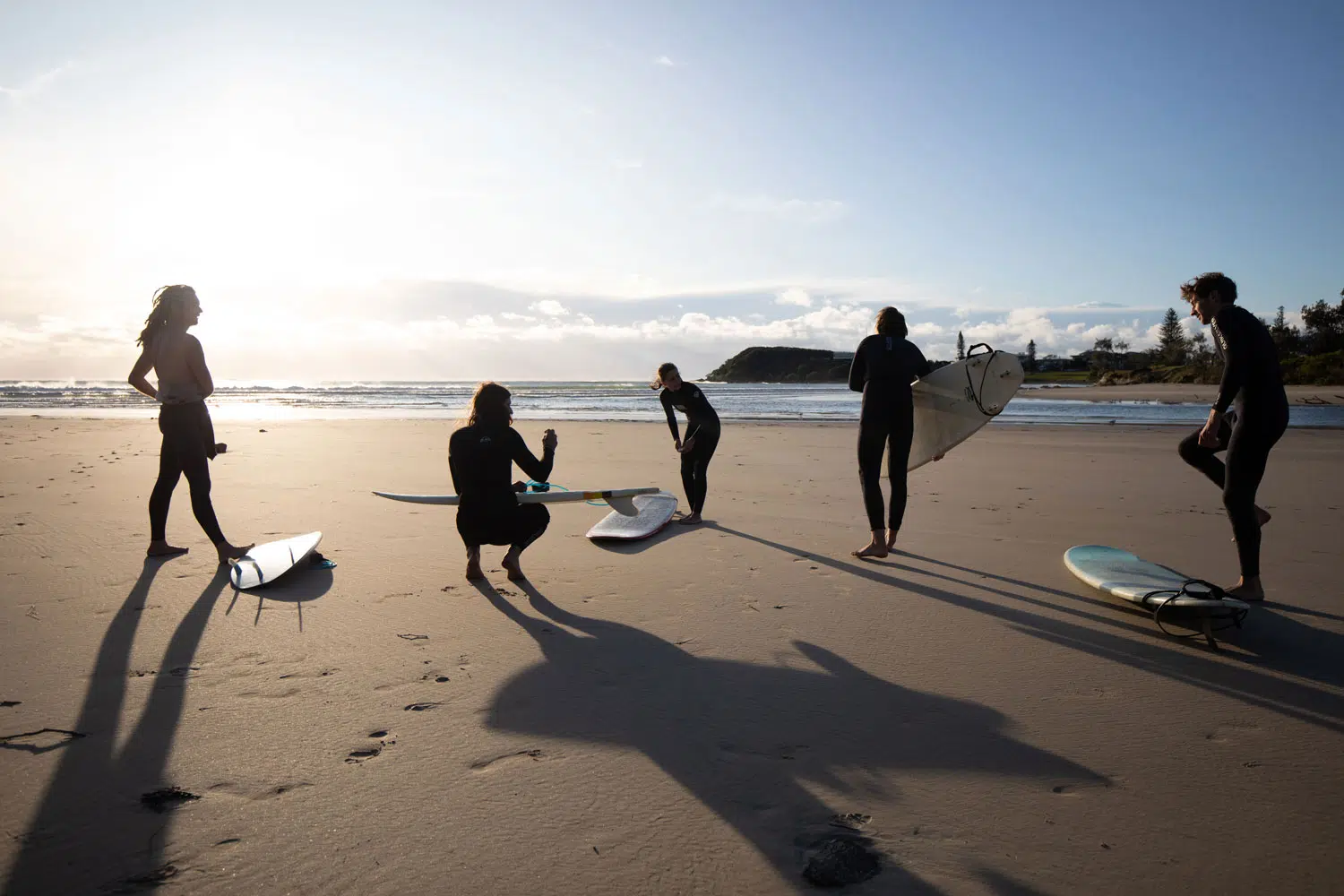 Surfers carrying boards on the beach at Spot X