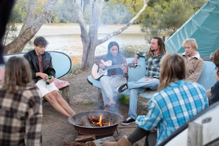 Guests sitting around a campfire at the Mojosurf camp