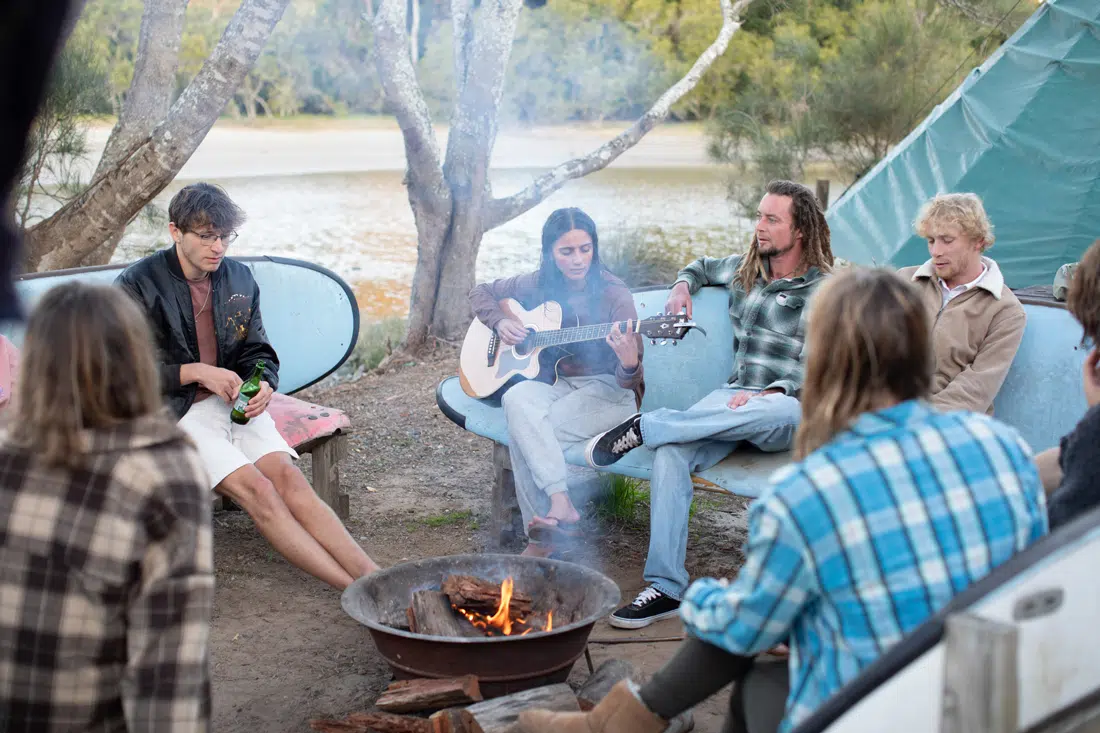 Guests sitting around a campfire at the Mojosurf camp