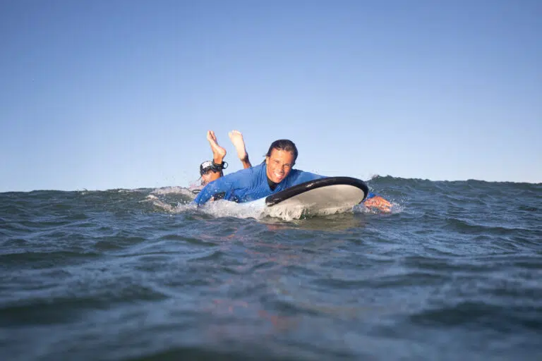Student riding a wave during a surf lesson at Spot X