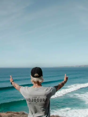 Surfer celebrating with arms raised in the ocean