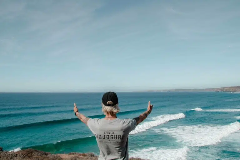 Surfer celebrating with arms raised in the ocean