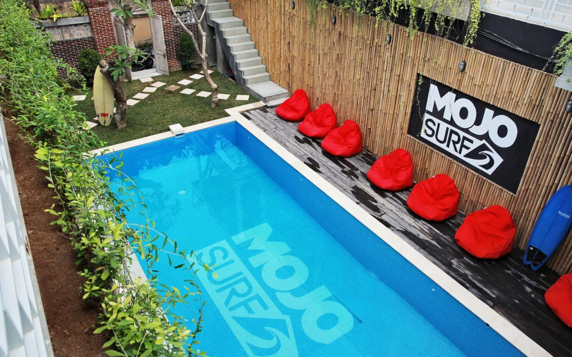 Pool and red loungers at a Mojosurf camp in Bali
