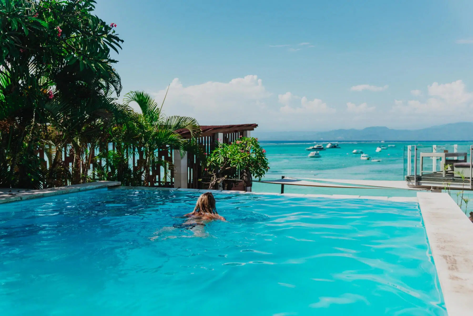 Guest in an infinity pool overlooking the sea in Bali