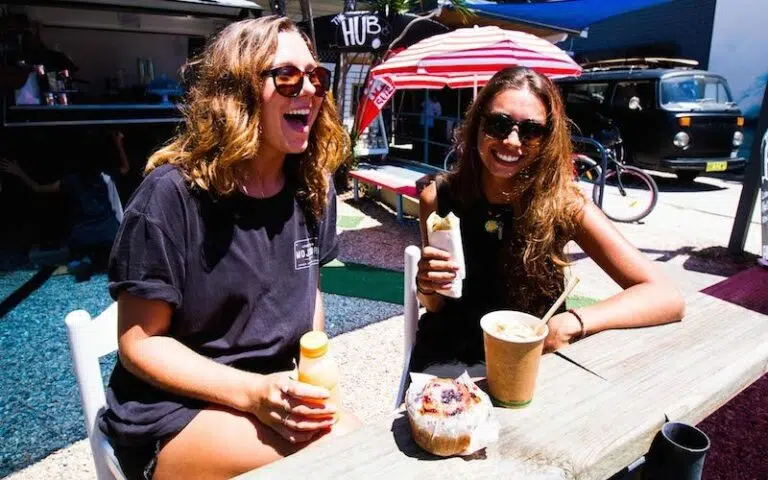 Guests laughing over drinks at the Spot X camp