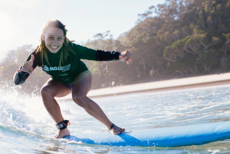 Smiling surfer riding a softboard at Byron Bay