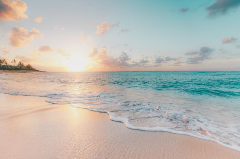 Waves washing onto a beach at sunset