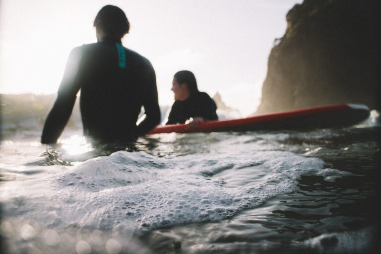 Surfers silhouetted in the whitewash at dusk