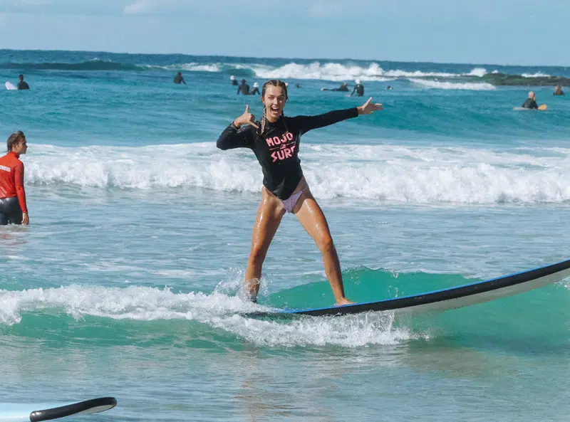 Learner surfer standing up on a softboard