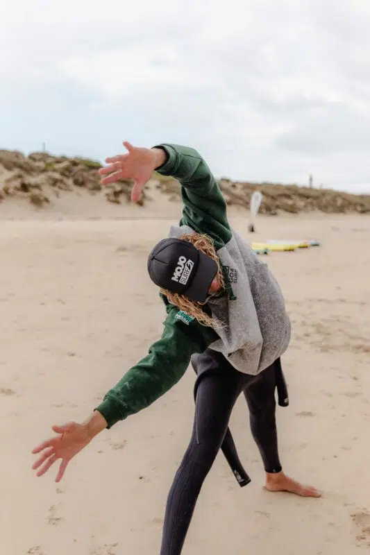 Surfer stretching on the beach in Peniche