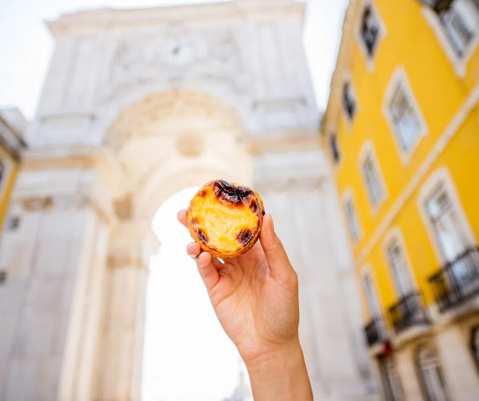Hand holding a pastel de nata on a Lisbon street